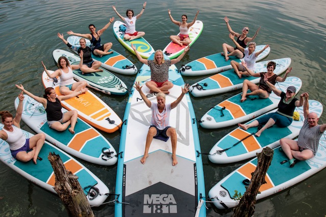 SUP Yoga mit Teilnehmerinnen auf dem See an der Boltenmühle